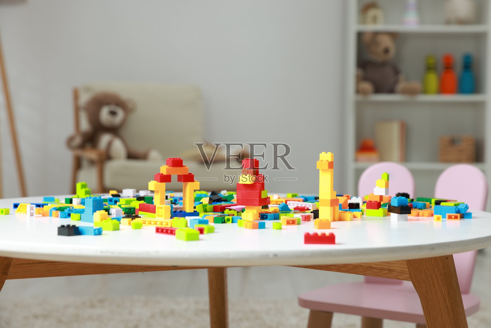 建筑玩具。在室内白桌上用积木和彩色积木制作的人物。照片摄影图片