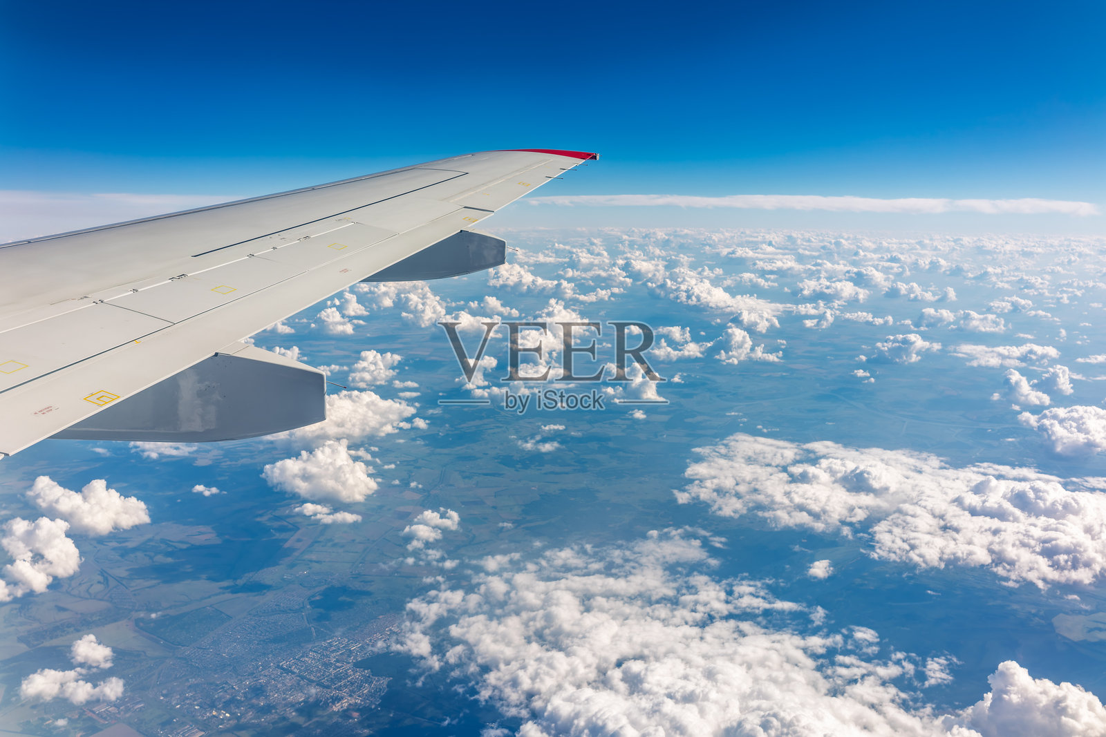 飞机舷窗外的云层密布,景色优美,还能看到飞机的机翼照片摄影图片
