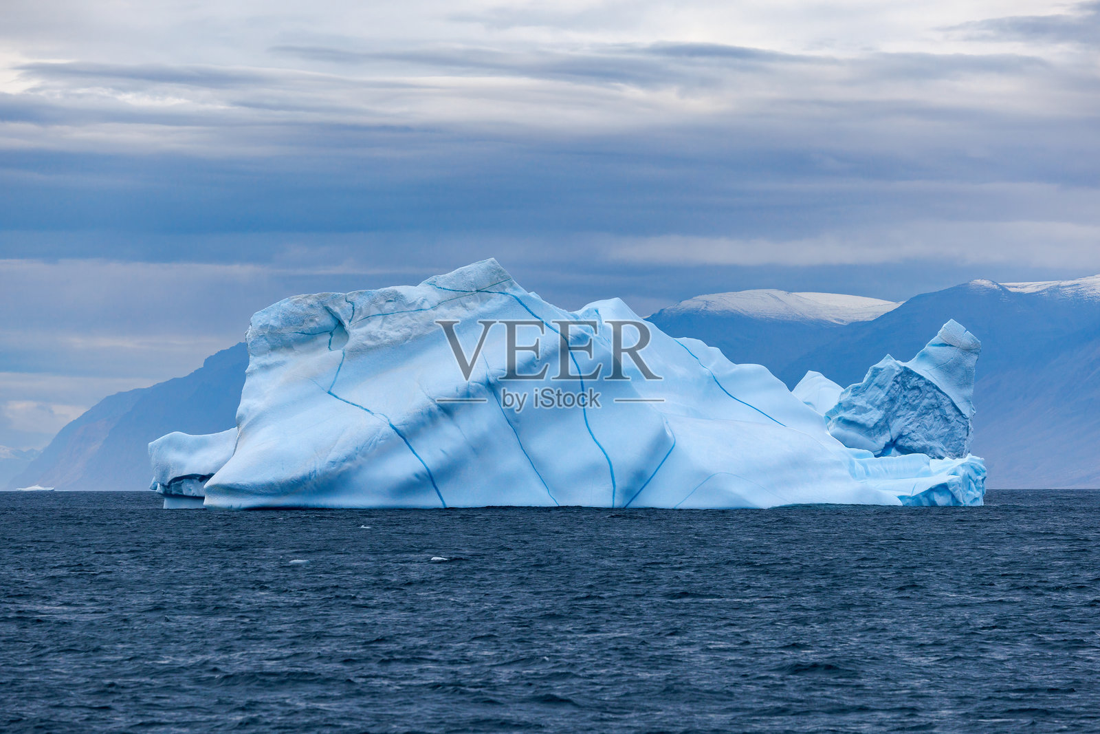 位于东北格陵兰国家公园邦特科岛,北冰洋寒冷蓝色水域中的冰山,带有蓝色纹理。照片摄影图片