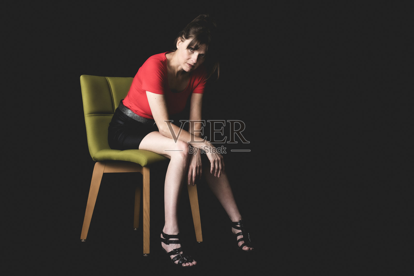 一位女士若有所思地向前坐着照片摄影图片