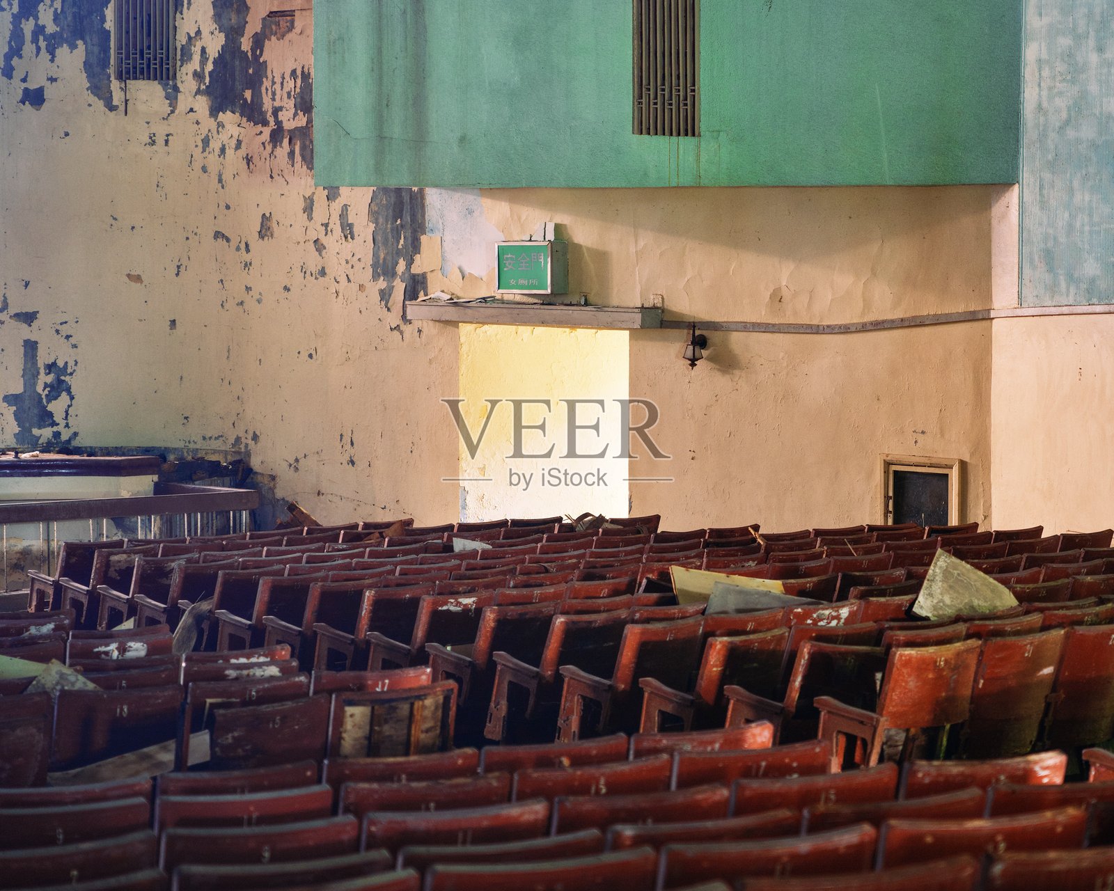 废弃破败的礼堂,排列着空荡荡的木椅 - 阴森的城市衰败室内场景照片摄影图片