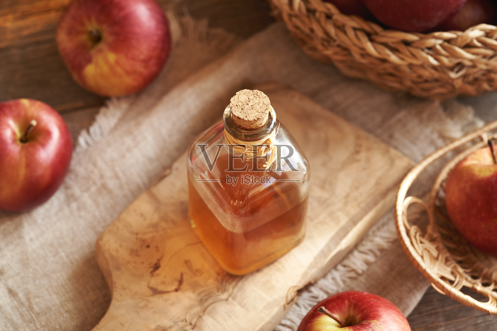 玻璃瓶装的苹果醋放在木桌上照片摄影图片