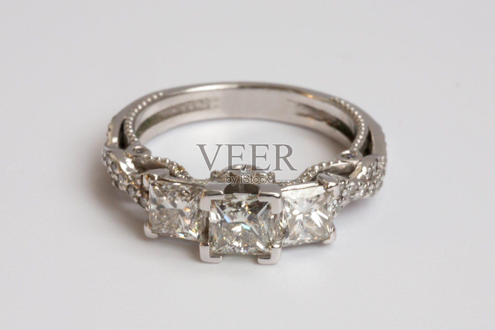 白色背景上的订婚钻戒组合。白金戒指镶嵌大克拉天然公主方形或改良明亮式切割钻石。照片摄影图片