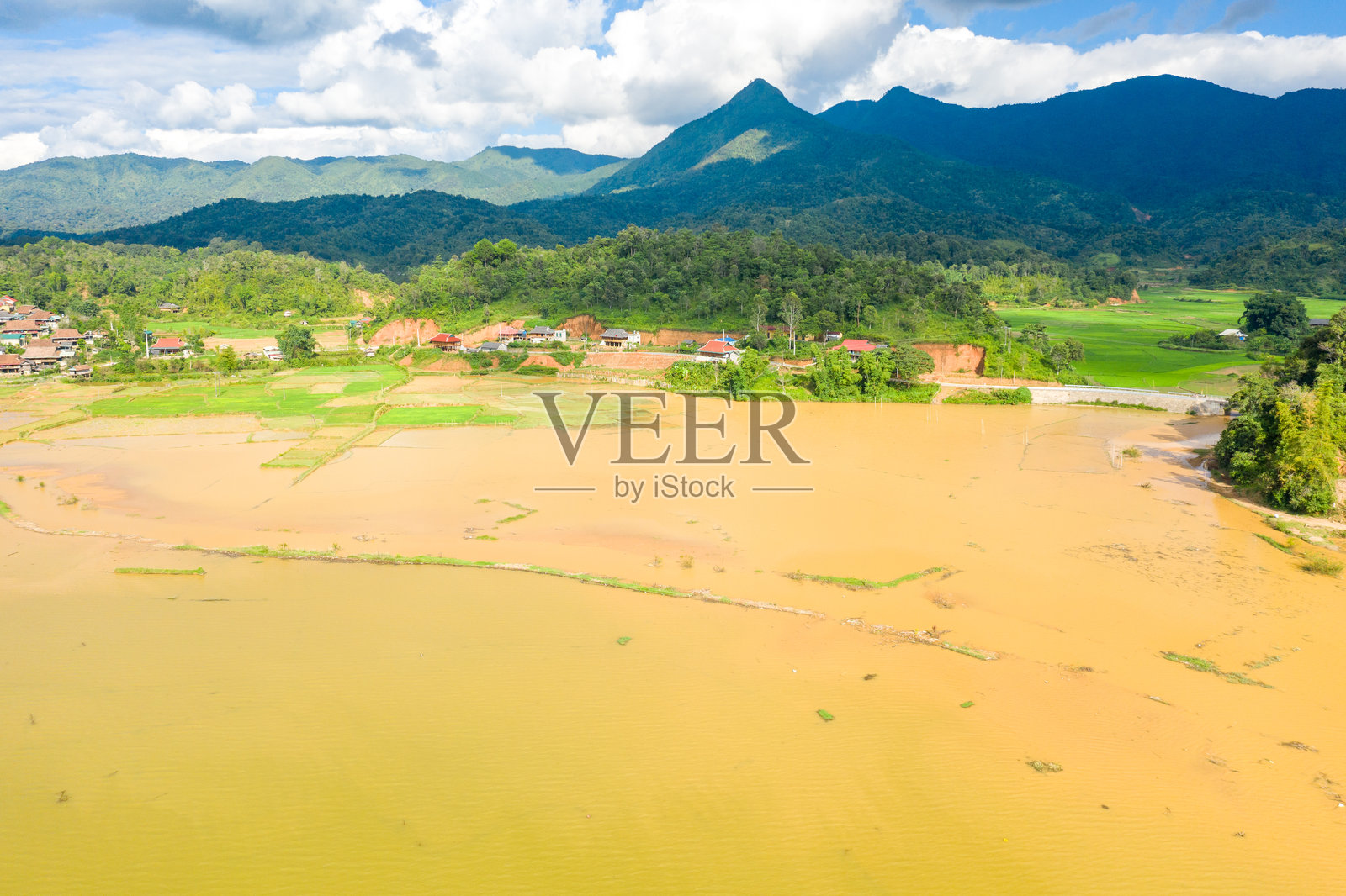 泥泞的湖泊和田野,背景为山峦照片摄影图片