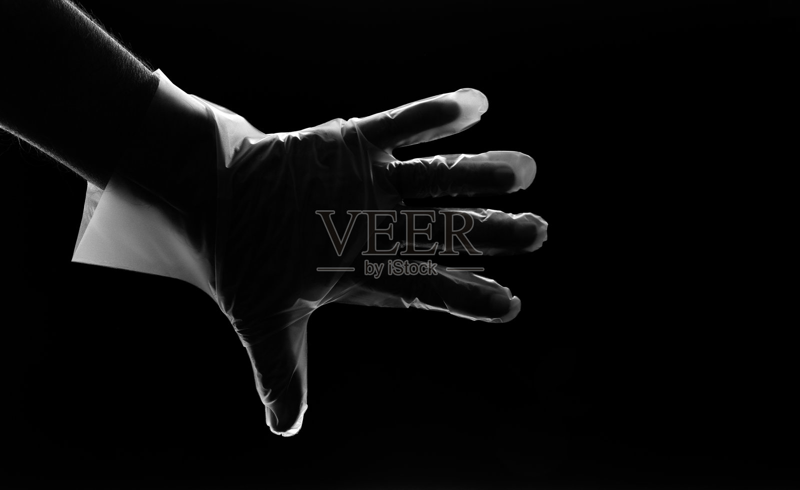 戴手套的手伸向黑色背景照片摄影图片