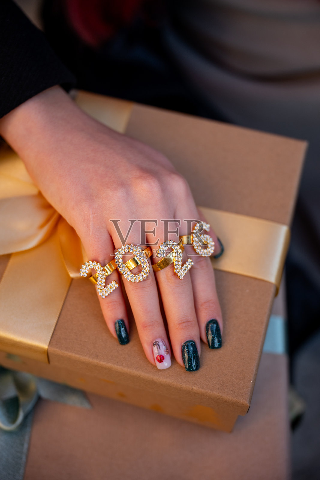 女性手持礼品盒,上面有2026数字戒指,新年概念美甲照片摄影图片