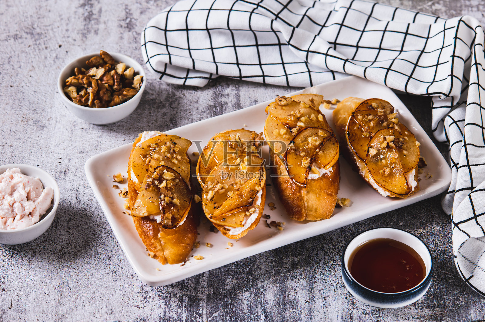 盘子里的美味吐司配奶油芝士、炸梨和蜂蜜,摆放在桌子上照片摄影图片