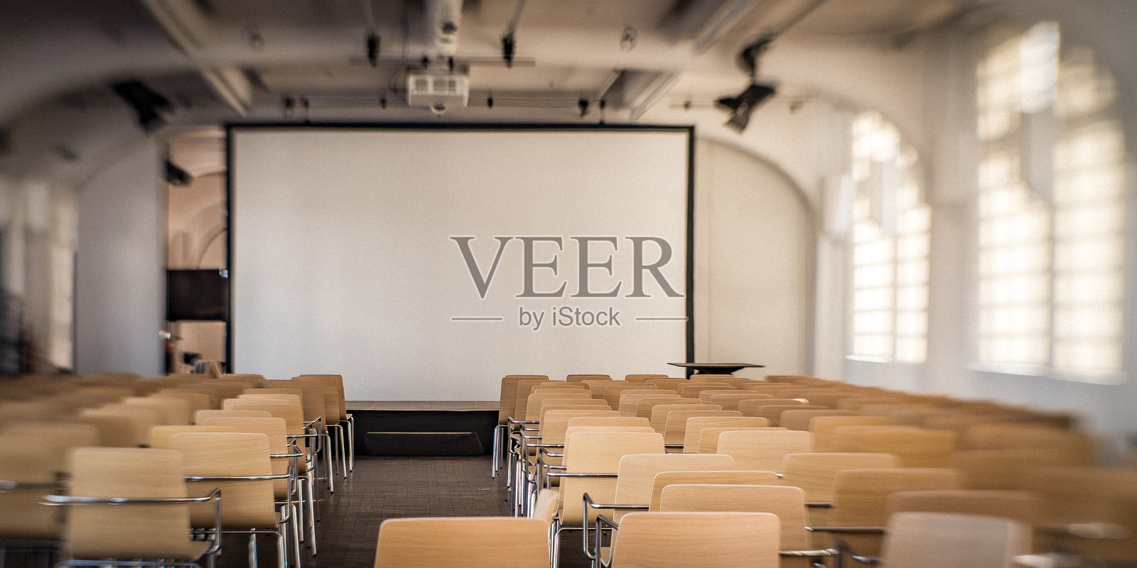 现代会议室,配有米色椅子和投影屏幕照片摄影图片