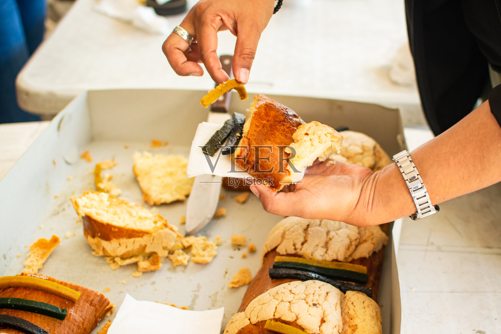 在国王节庆祝活动中,人们分享罗丝卡德雷耶斯面包照片摄影图片