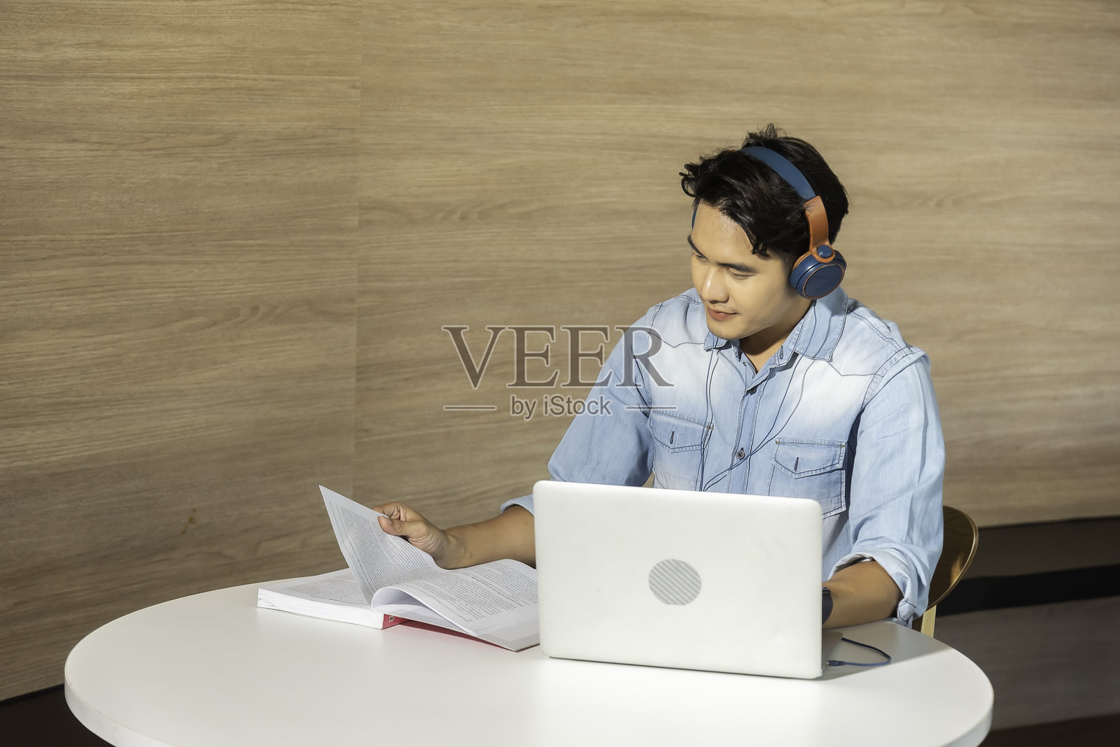 快乐的亚洲呼叫中心代理,戴着耳机,在客服办公室与客户交谈。照片摄影图片