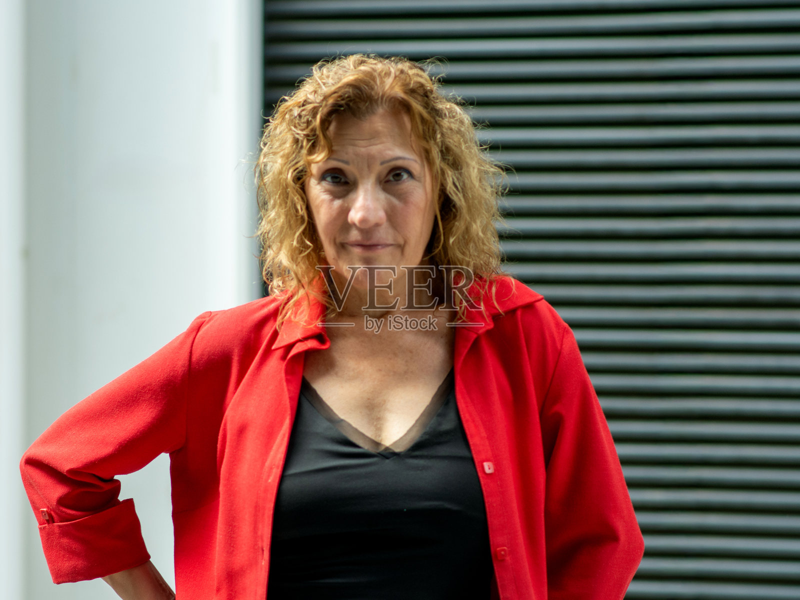 穿着红色衬衫的成熟成年女性,看向镜头照片摄影图片