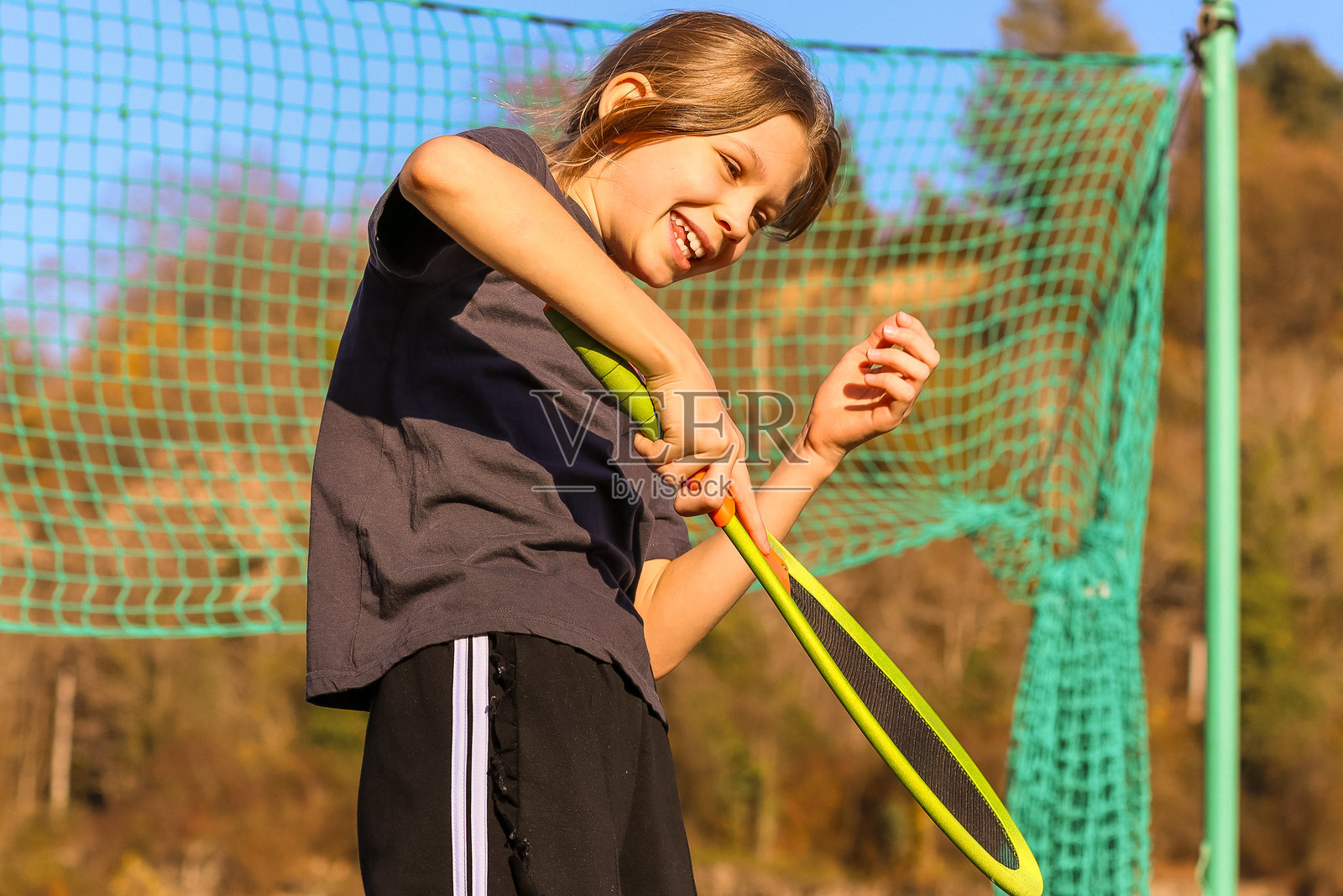 年轻女孩在户外开心地笑着打羽毛球照片摄影图片