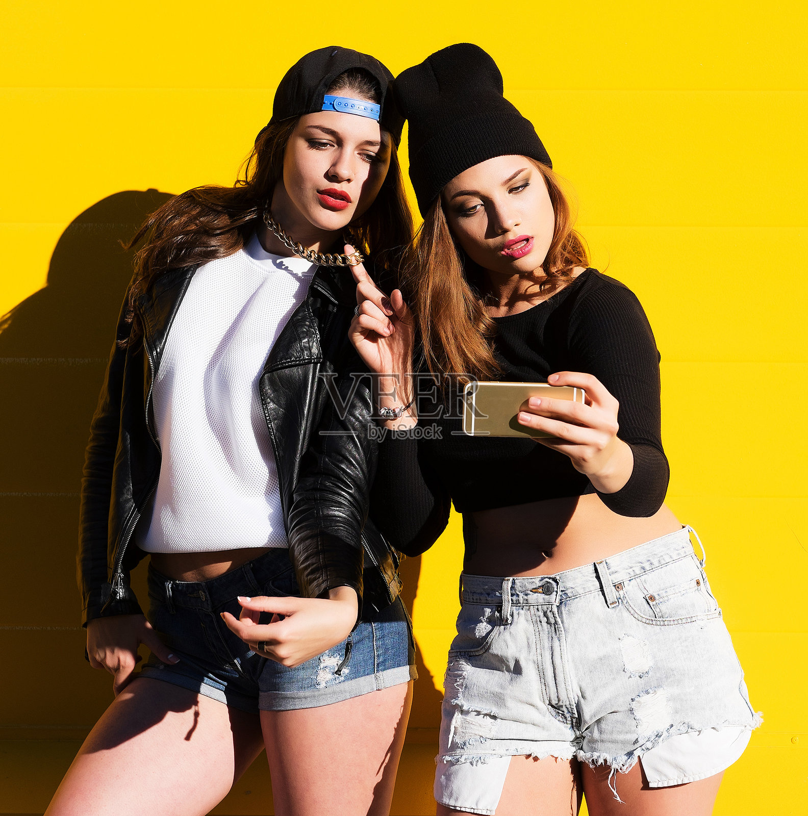 一群少女朋友在户外用手机自拍。照片摄影图片