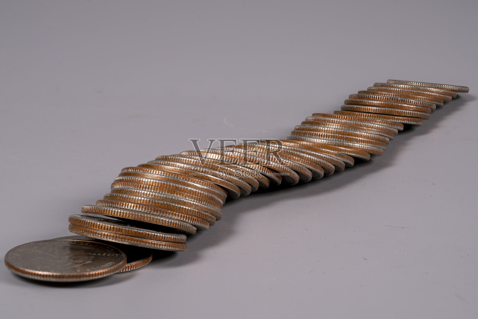 硬币在纯灰色表面上堆叠成螺旋状照片摄影图片