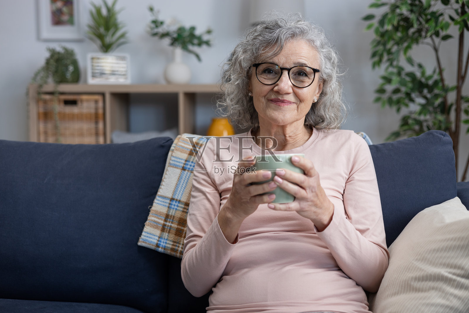 一位年长的女性在家中放松,享受热饮照片摄影图片