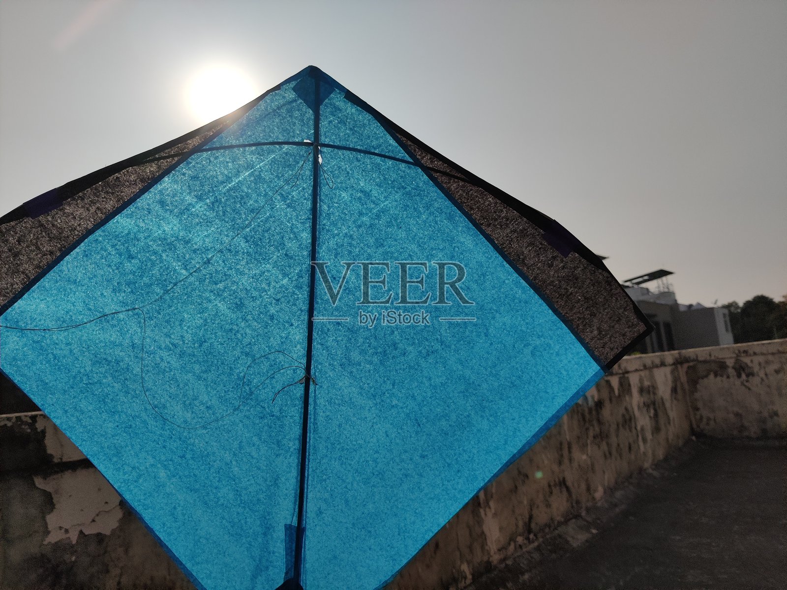 蓝黑相间的风筝在明媚的晴空下翱翔照片摄影图片