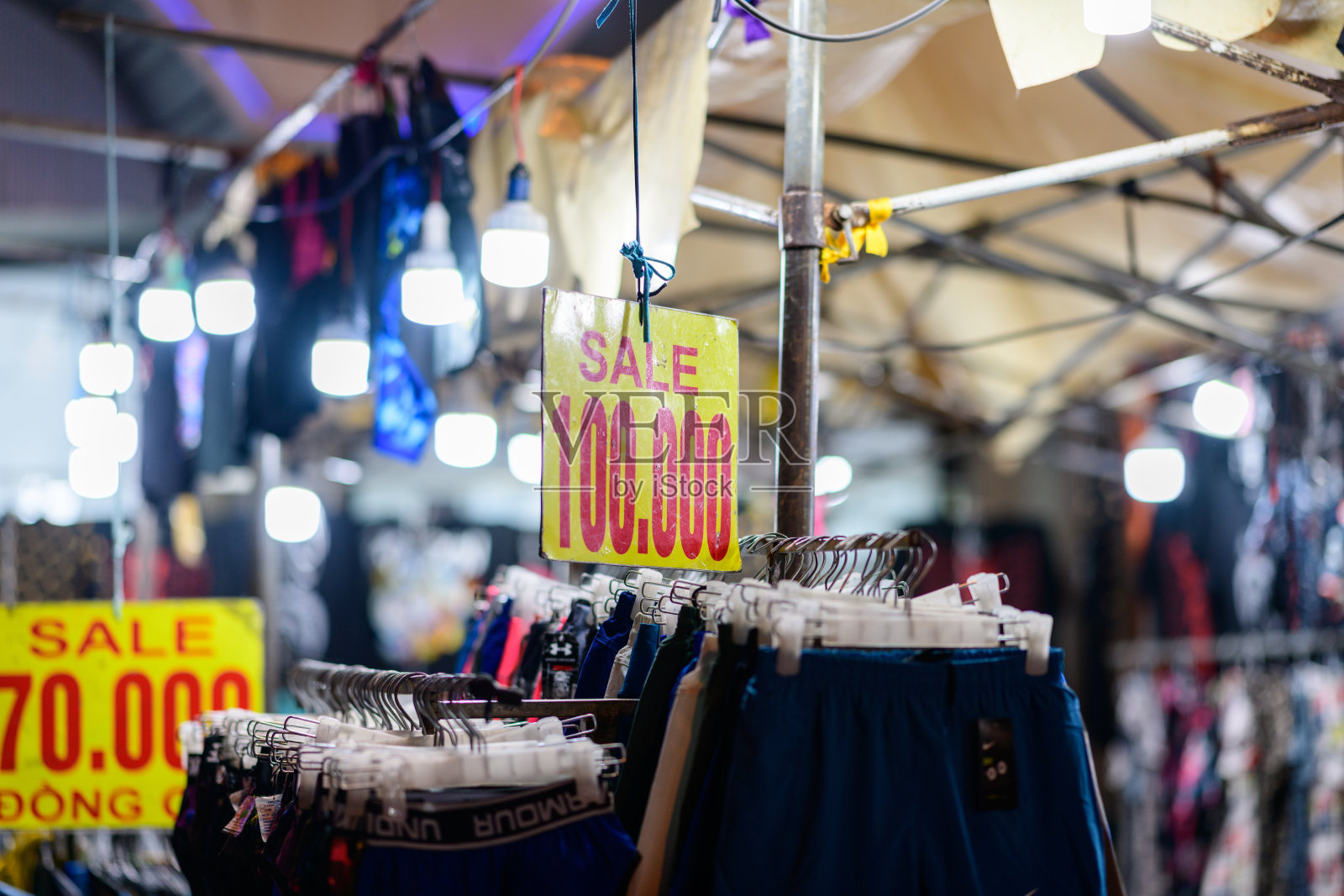 夜市服装架,带有促销标志照片摄影图片