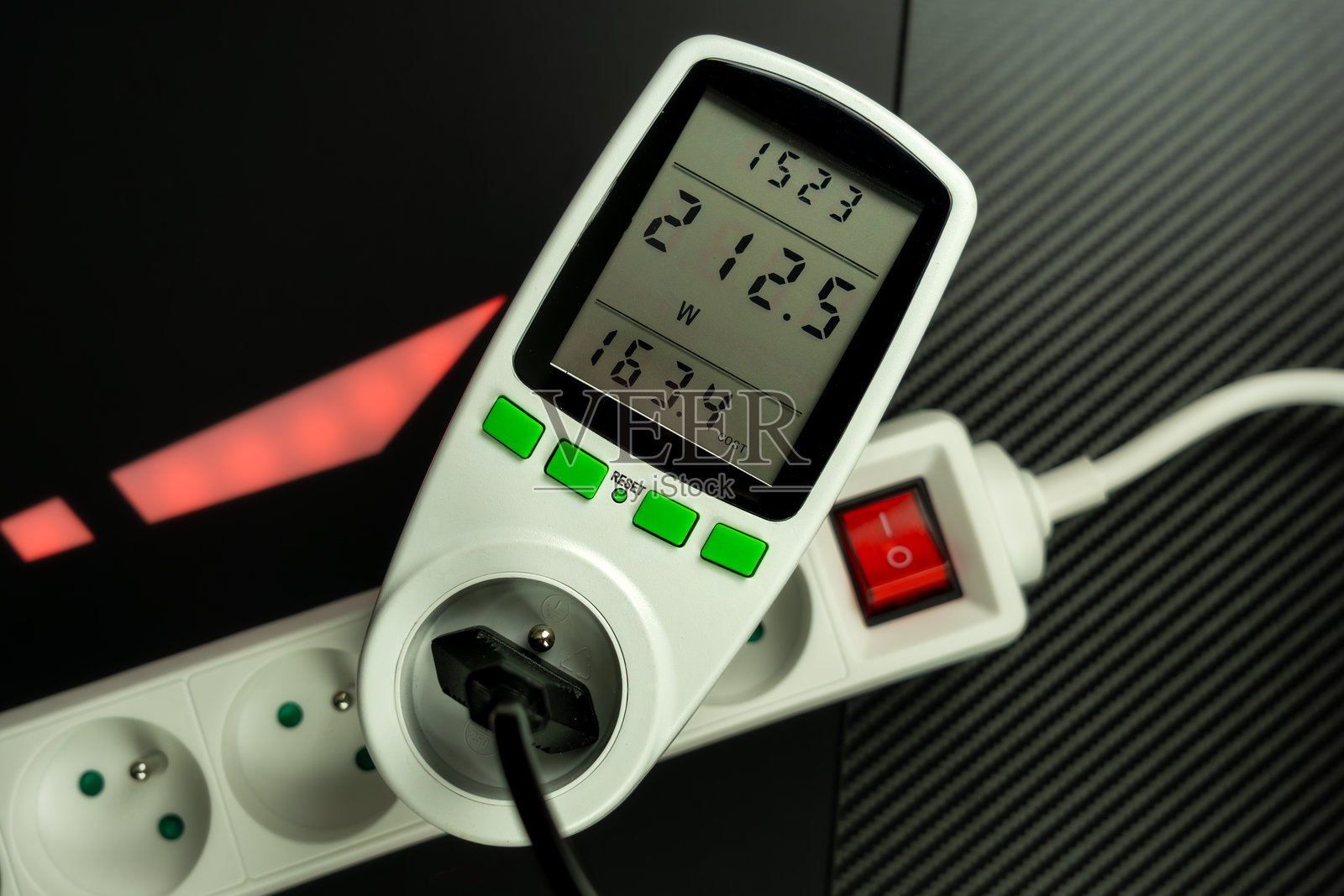 高用电量数字瓦特计(功率计)特写,插入白色欧式电源插座带有红色开关,用于能源监测和成本核算照片摄影图片