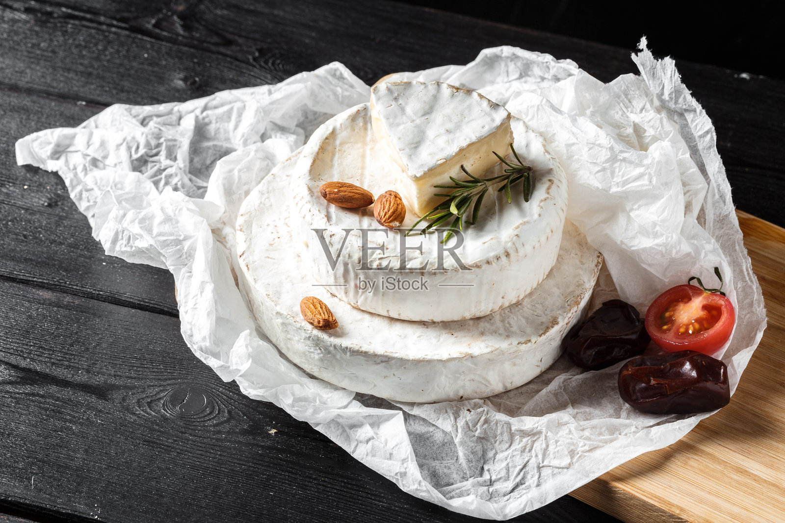 质朴的木板上摆放着精选的奶酪、坚果和新鲜水果照片摄影图片