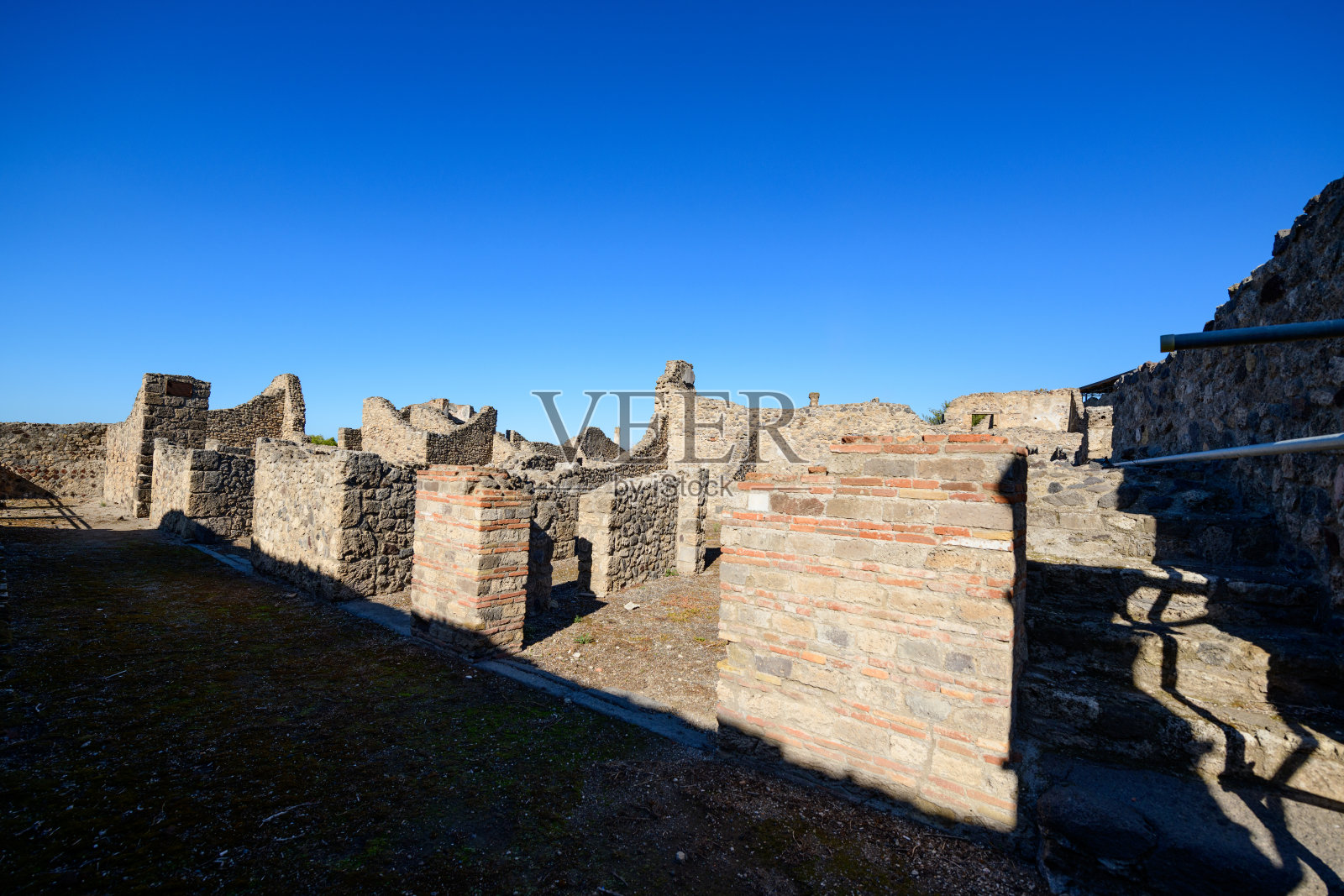 庞贝古城街道上的石头遗迹和砖墙照片摄影图片