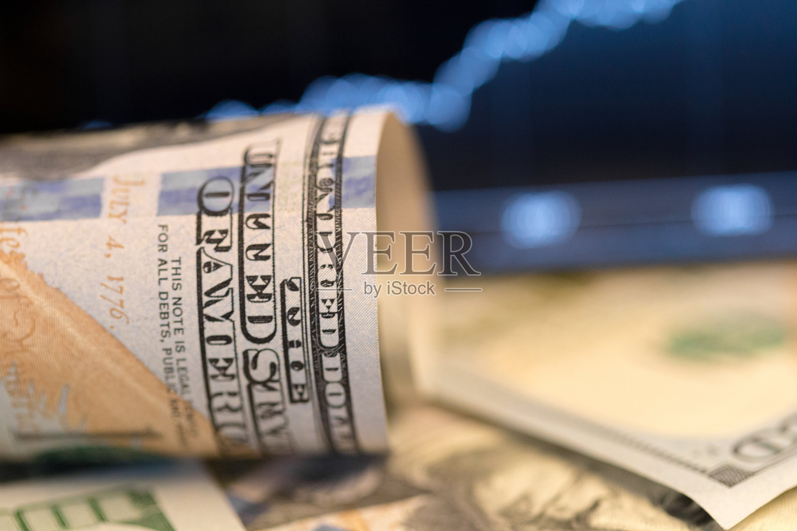 美元钞票散落,背景为展示市场趋势的金融图表照片摄影图片