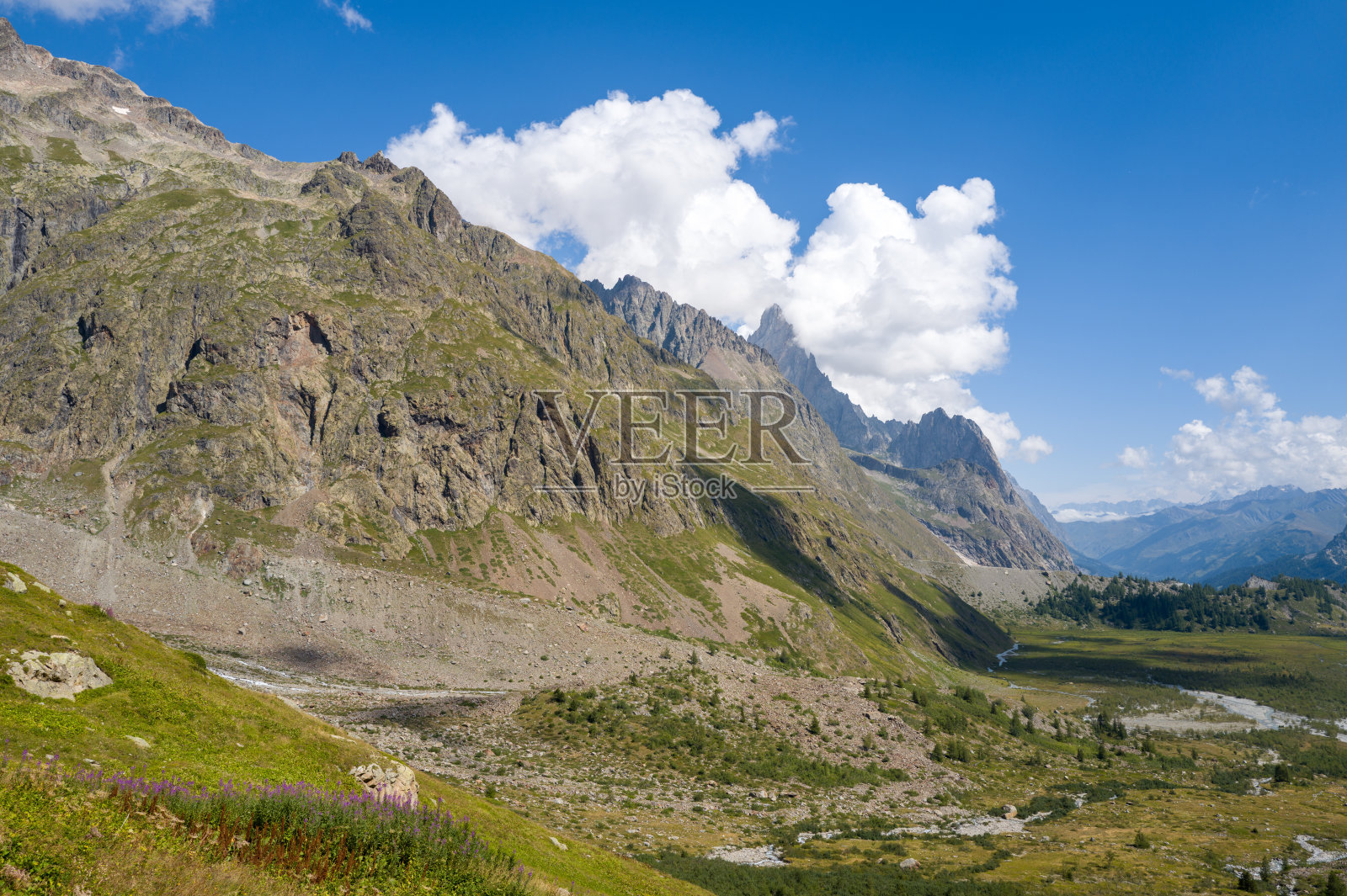 郁郁葱葱的意大利阿尔卑斯山谷上方的戏剧性岩石山峰照片摄影图片