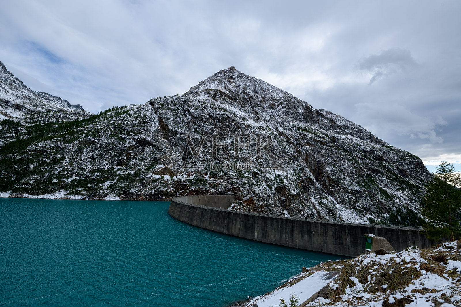 雪山阿尔卑斯山弯曲的大坝和绿松石色的湖泊照片摄影图片