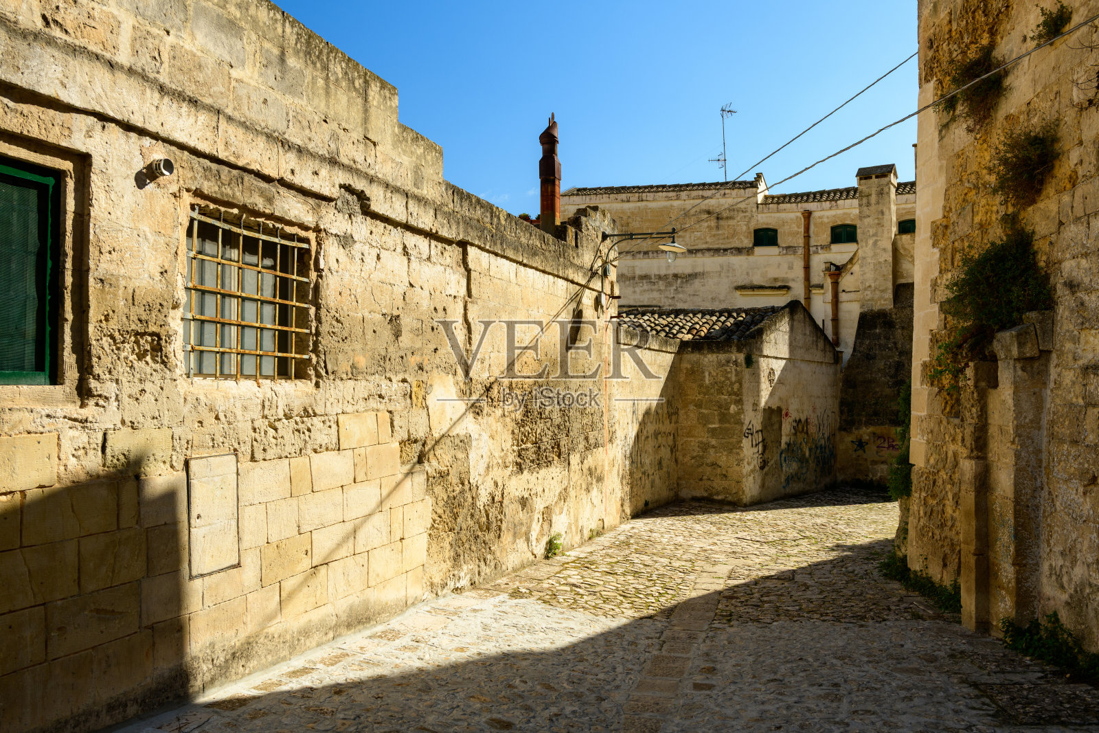 马泰拉老城阳光下的鹅卵石小巷照片摄影图片