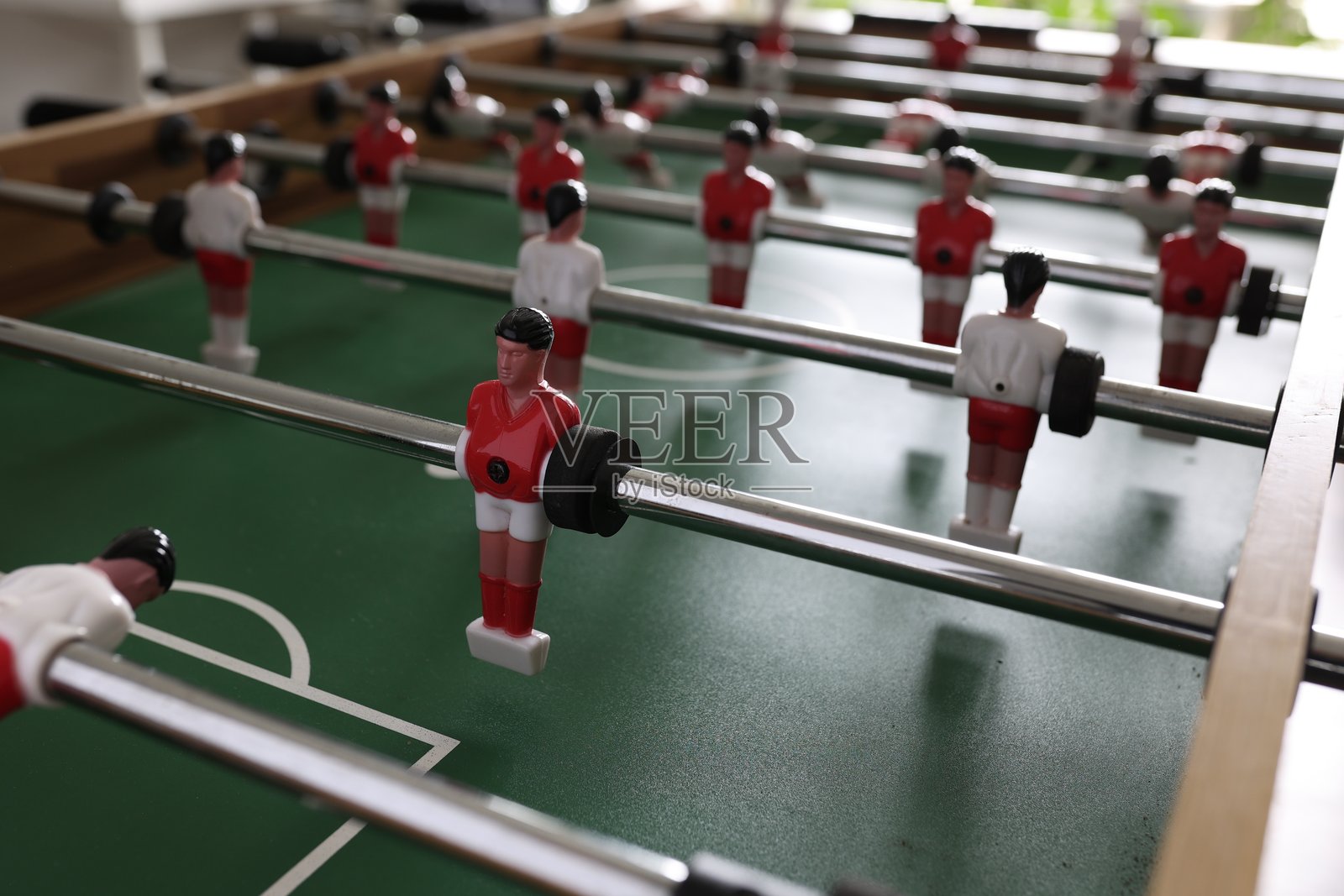 画好的微缩模型摆放在旋转杆上,背景是光滑的绿色草地。照片摄影图片