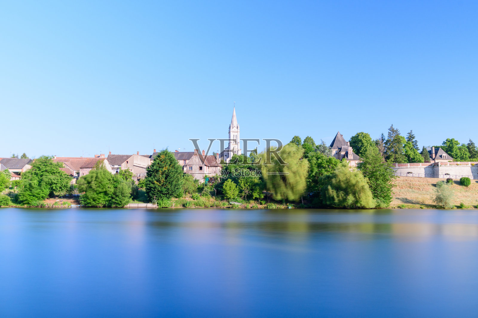 法国丹皮埃尔昂布尔利宁静的池塘和教堂塔楼照片摄影图片