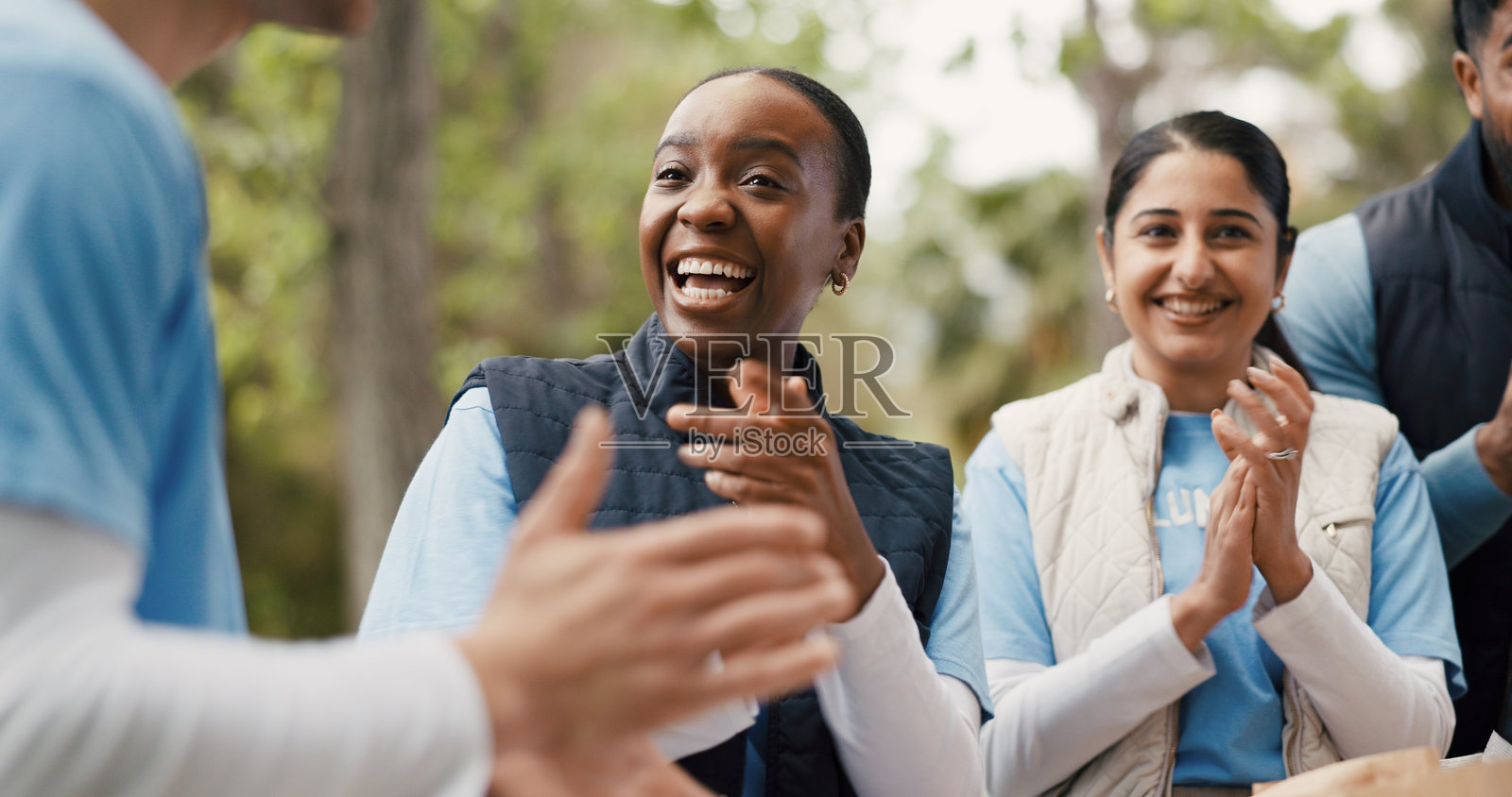 户外,志愿者们为项目鼓掌,慈善活动圆满成功,筹款活动或项目取得成功,人们鼓掌庆祝非政府组织的成就,体现人道主义和社会责任照片摄影图片
