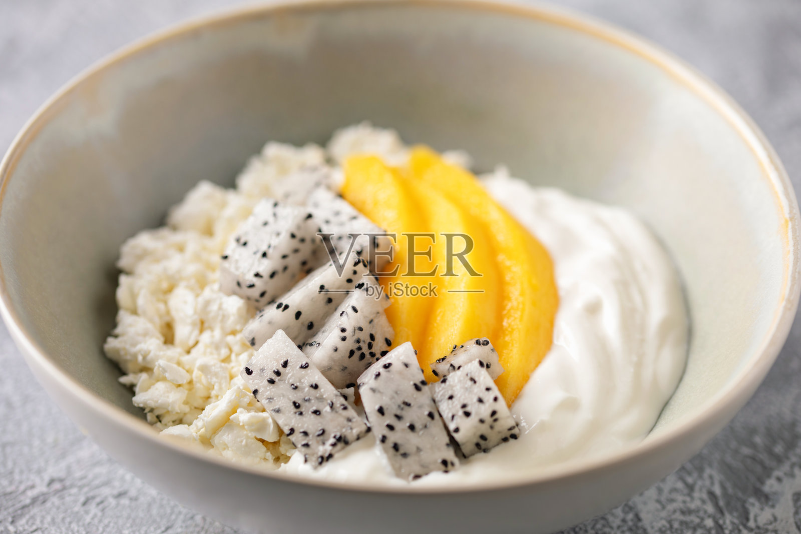 健康的早餐。碗里盛着农家奶酪、酸奶和水果,摆在桌子上。照片摄影图片