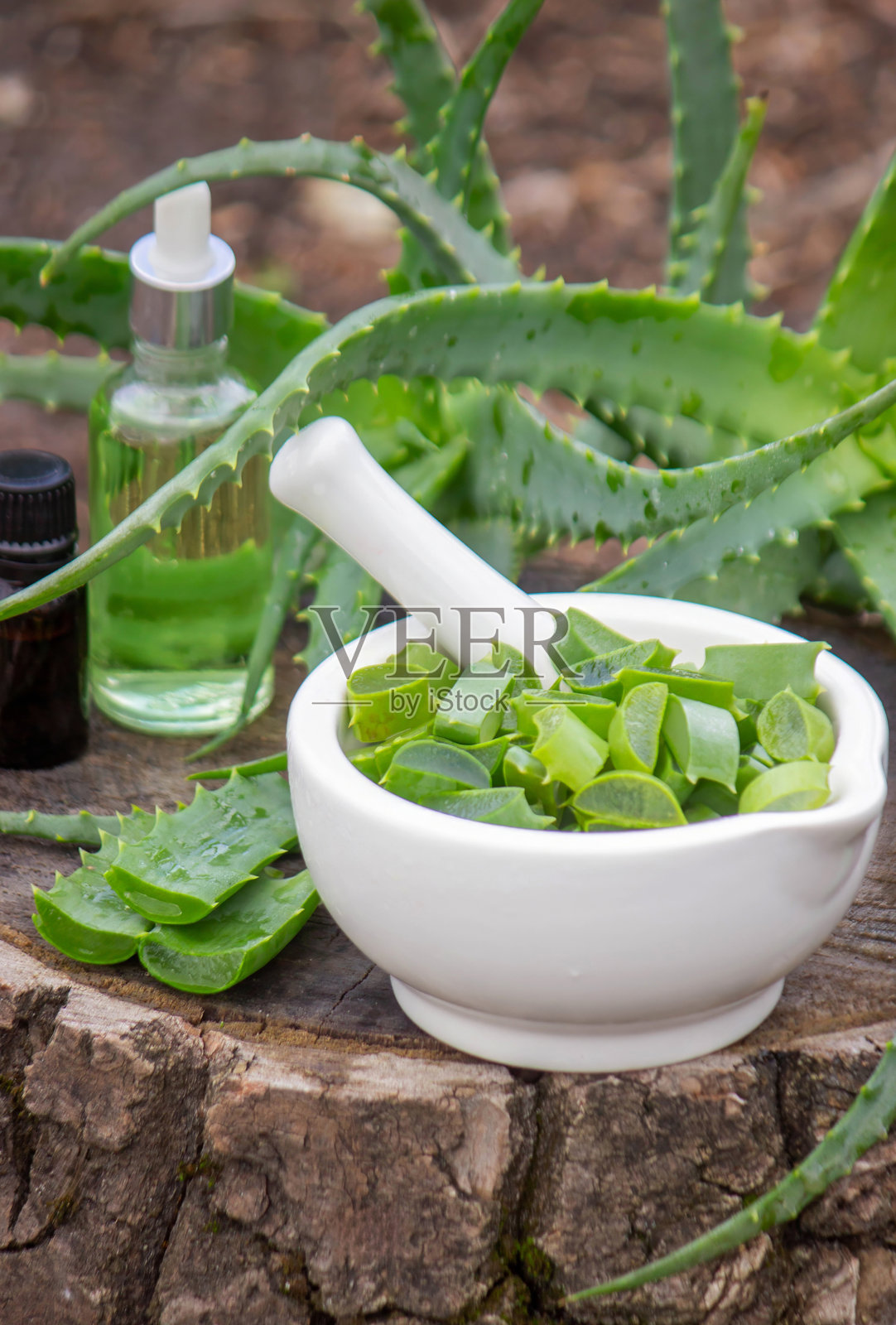 精油瓶和新鲜的芦荟叶。天然有机化妆品照片摄影图片