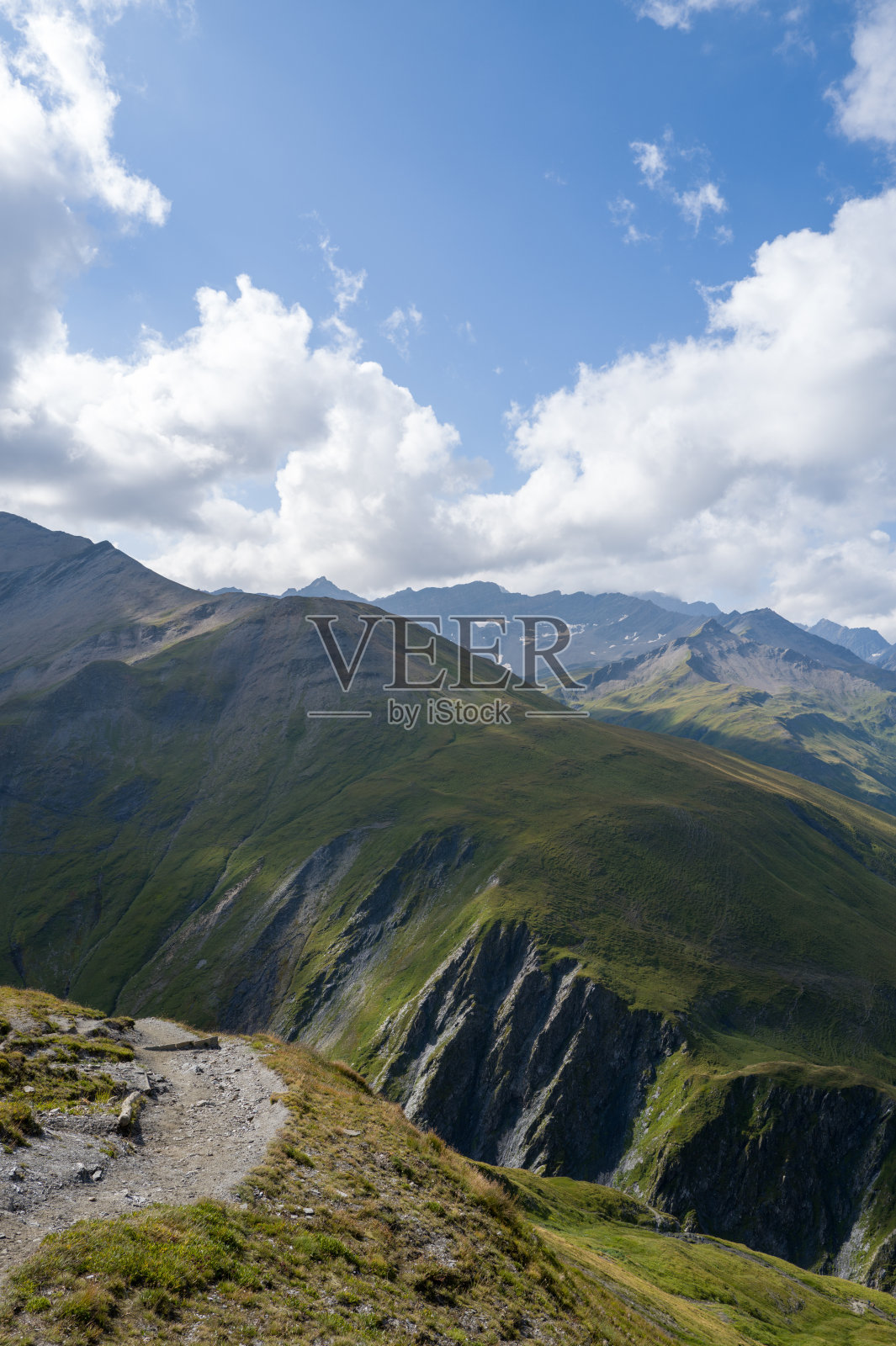 俯瞰深绿色山谷的阿尔卑斯山小径照片摄影图片
