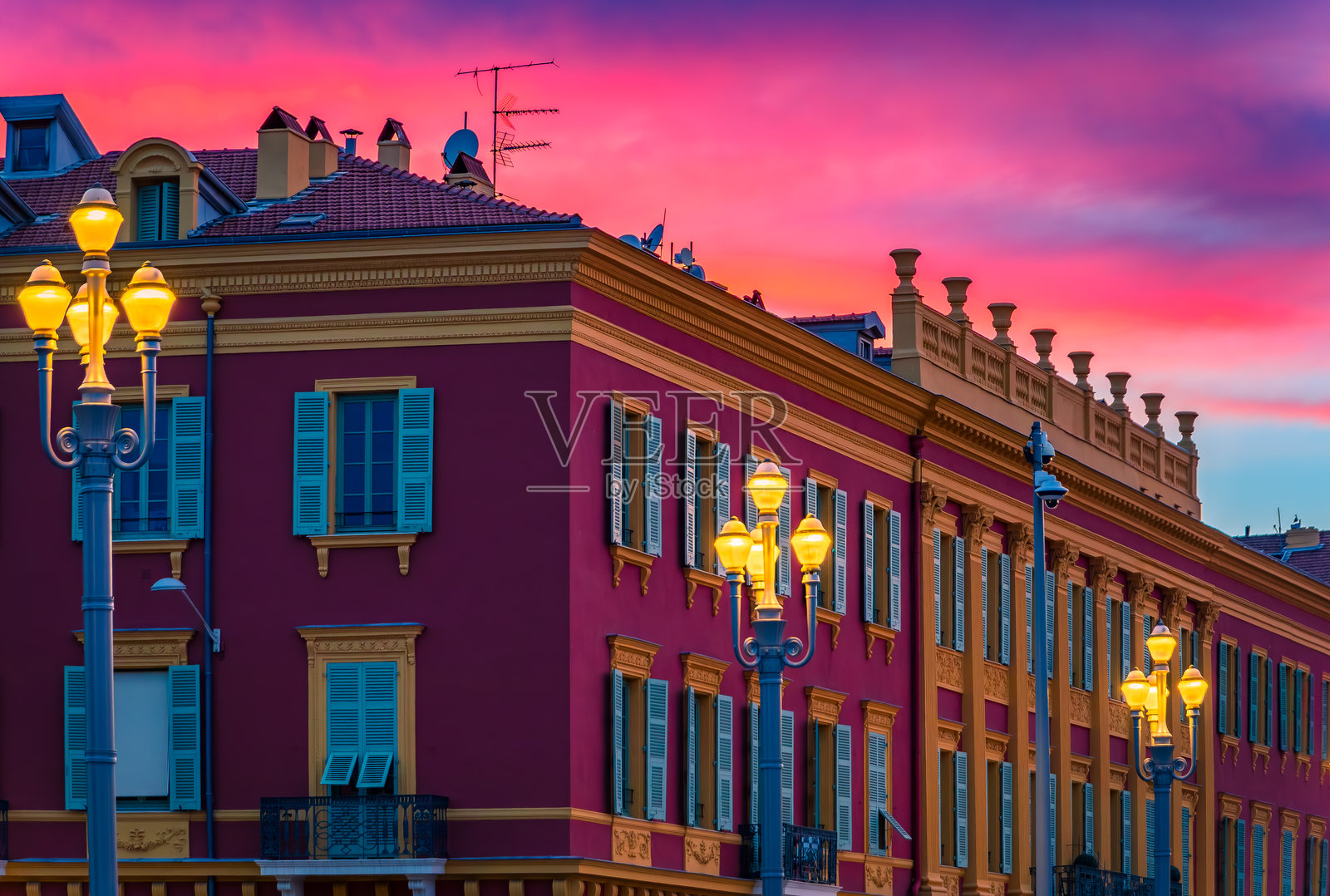 法国尼斯马塞纳广场上色彩缤纷的建筑上空,绚烂的日落景象照片摄影图片