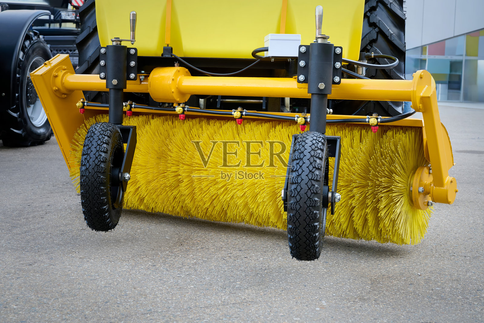 带有清扫附件的拖拉机在城市街道上作业。照片摄影图片