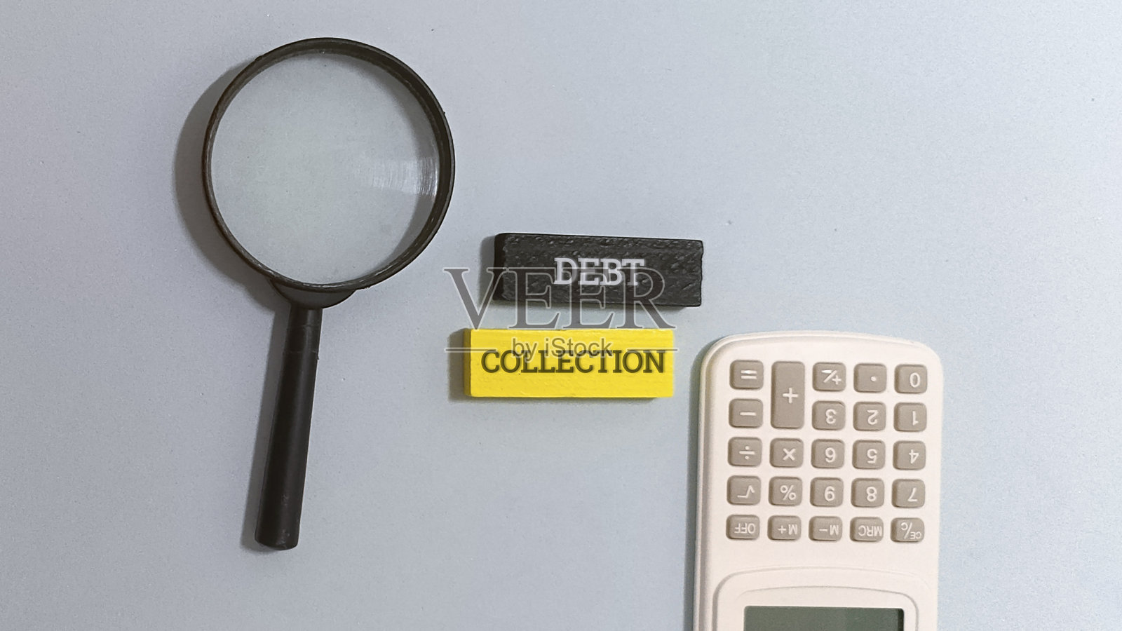 债务催收概念,配有放大镜和计算器照片摄影图片