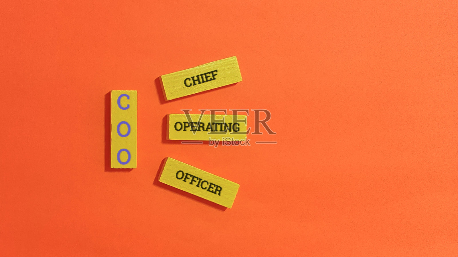 首席运营官 橙色背景上的木块照片摄影图片