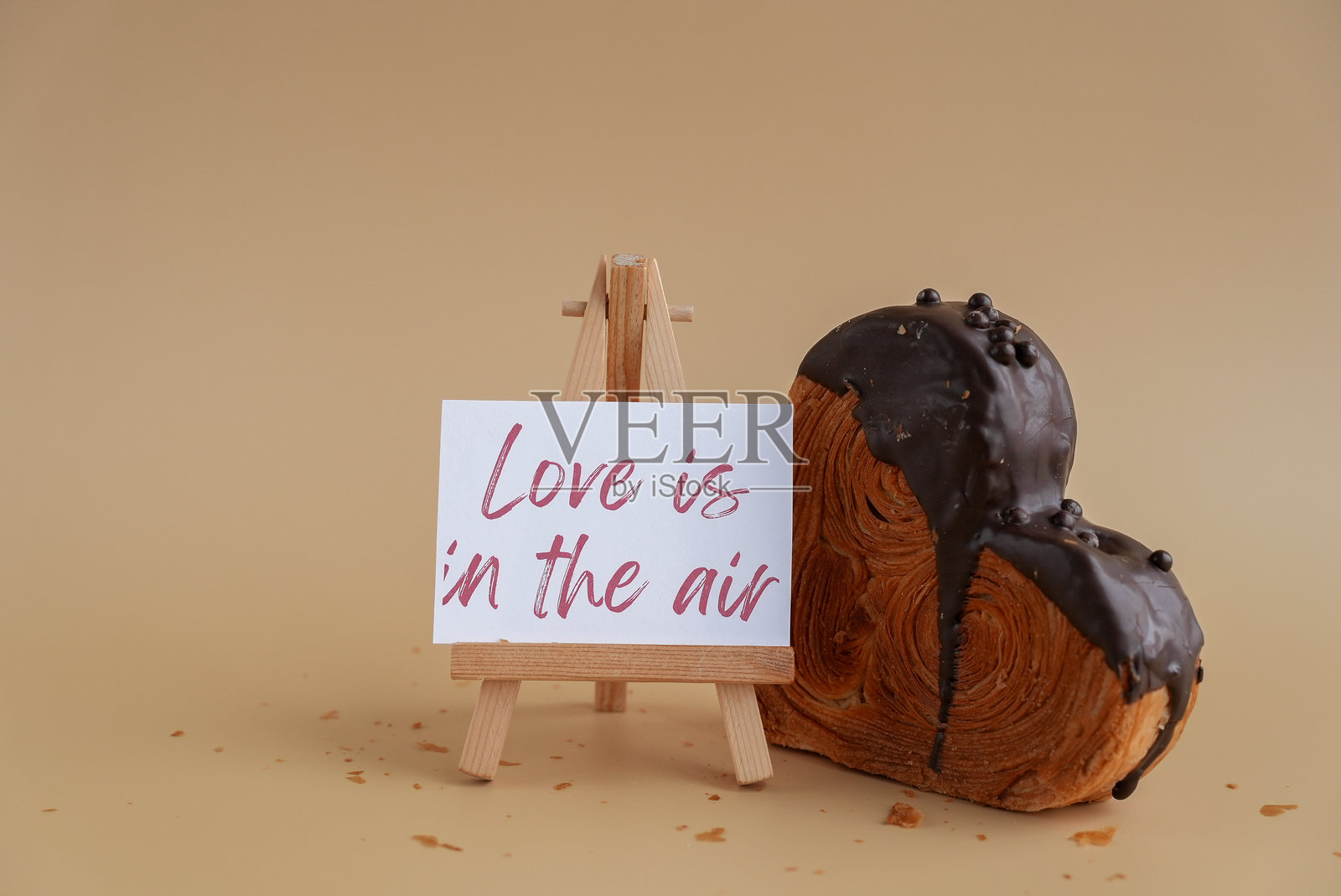 爱意弥漫 贺卡上的祝福语 令人愉悦的心形糕点羊角面包,装饰着琳琅满目的彩色糖霜。可供复制的空间。美食实验 病毒式甜点 创意烘焙趋势照片摄影图片