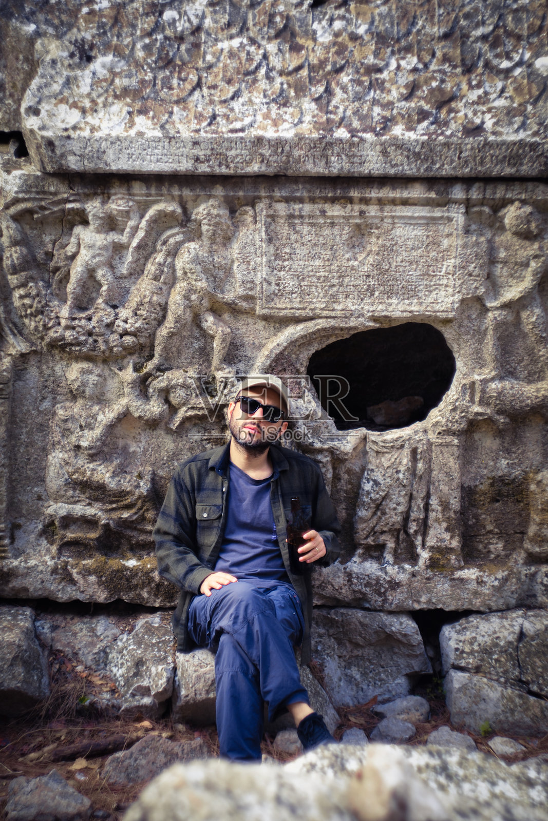 一位旅行者在古老的石棺旁沉思他过往的人生。照片摄影图片