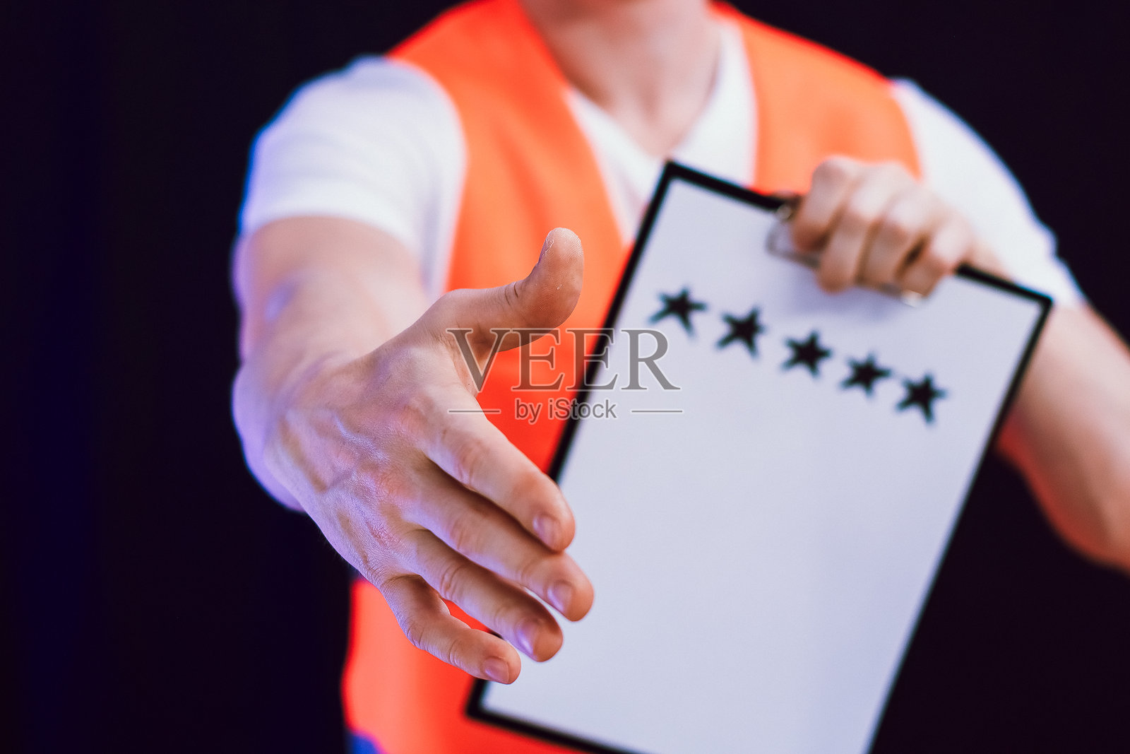 一名工人递出带有五星好评剪贴板的手照片摄影图片