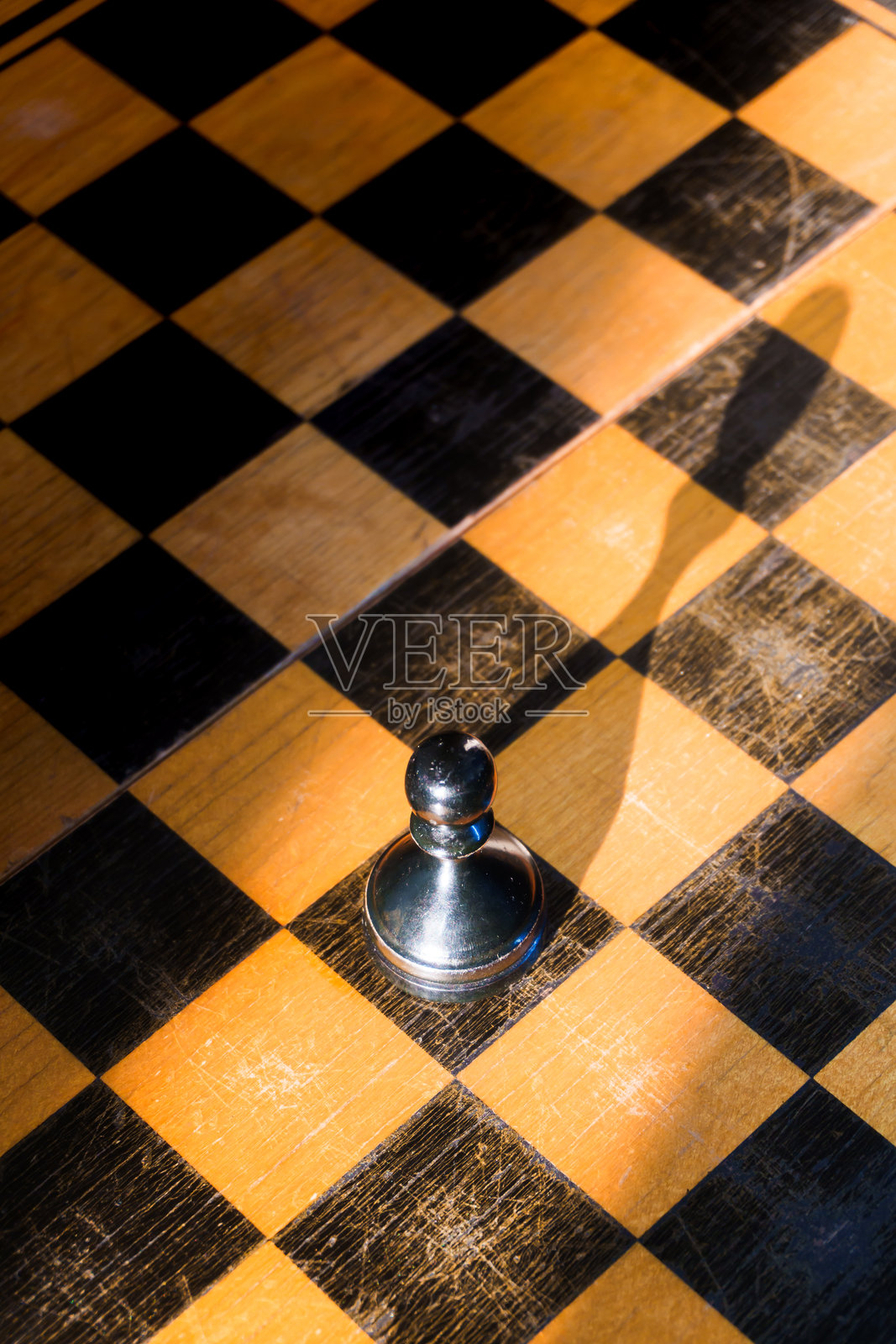 棋盘上的棋子,旧的木制棋子,黑或棕色,白棋中的一个黑兵,不同而特别,黑方先行,赢棋,国际象棋比赛,国际象棋冠军赛照片摄影图片