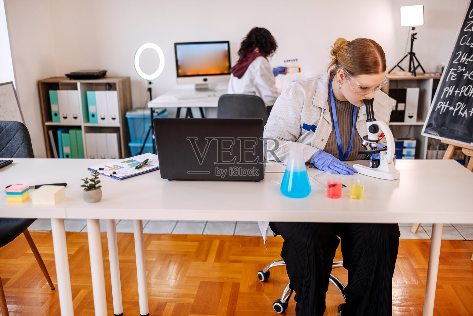 年轻的科学家们在实验室里使用显微镜进行研究照片摄影图片