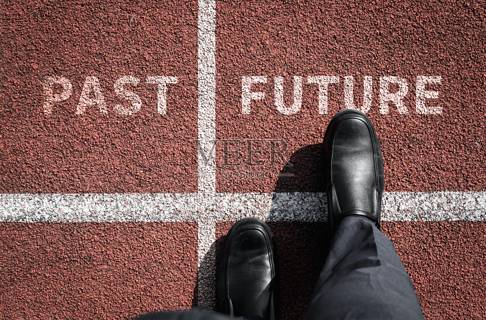 俯视一名商人,他身后用一条白线隔开“PAST”(过去)和“FUTURE”(未来)这两个词。照片摄影图片