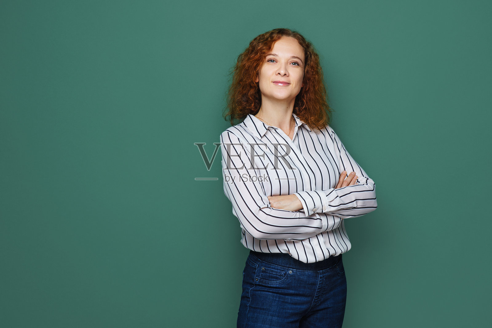 微笑的女商人在多彩背景前抱臂看向镜头照片摄影图片