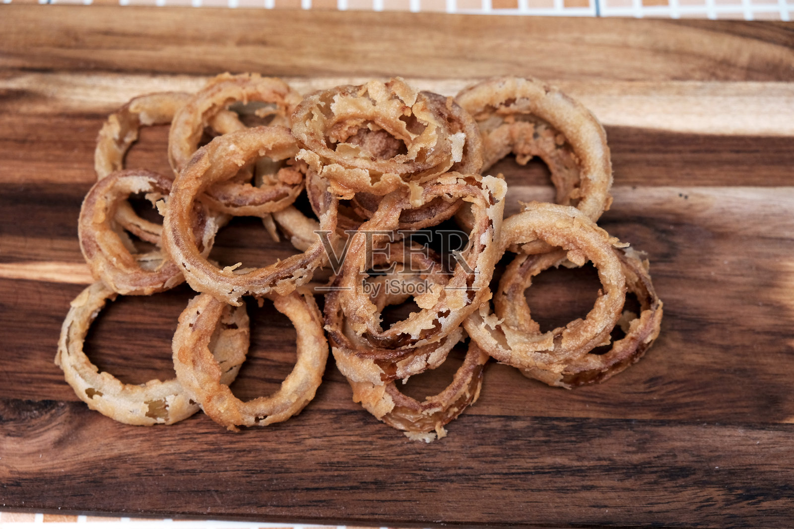 自制酥脆炸洋葱圈放在木板上。自制洋葱圈。自制食物照片摄影图片