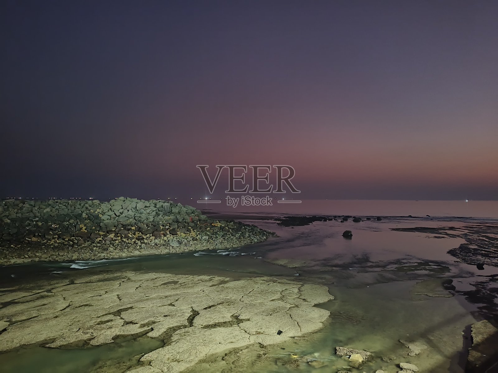 黄昏时分,岩石海滩上的宁静时刻。照片摄影图片