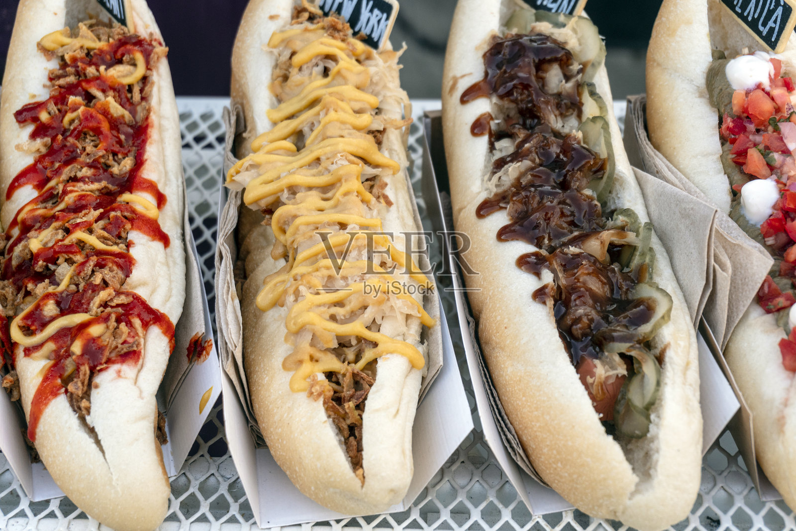 食品车上摆放着一排排淋上酱汁的新鲜热狗照片摄影图片