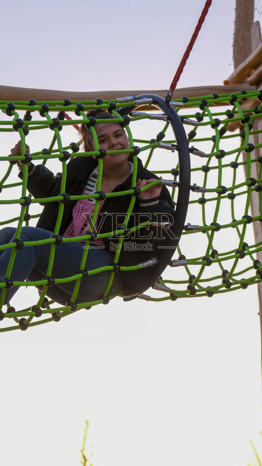 可爱的小女孩在公园的儿童游乐场玩耍,非常开心照片摄影图片