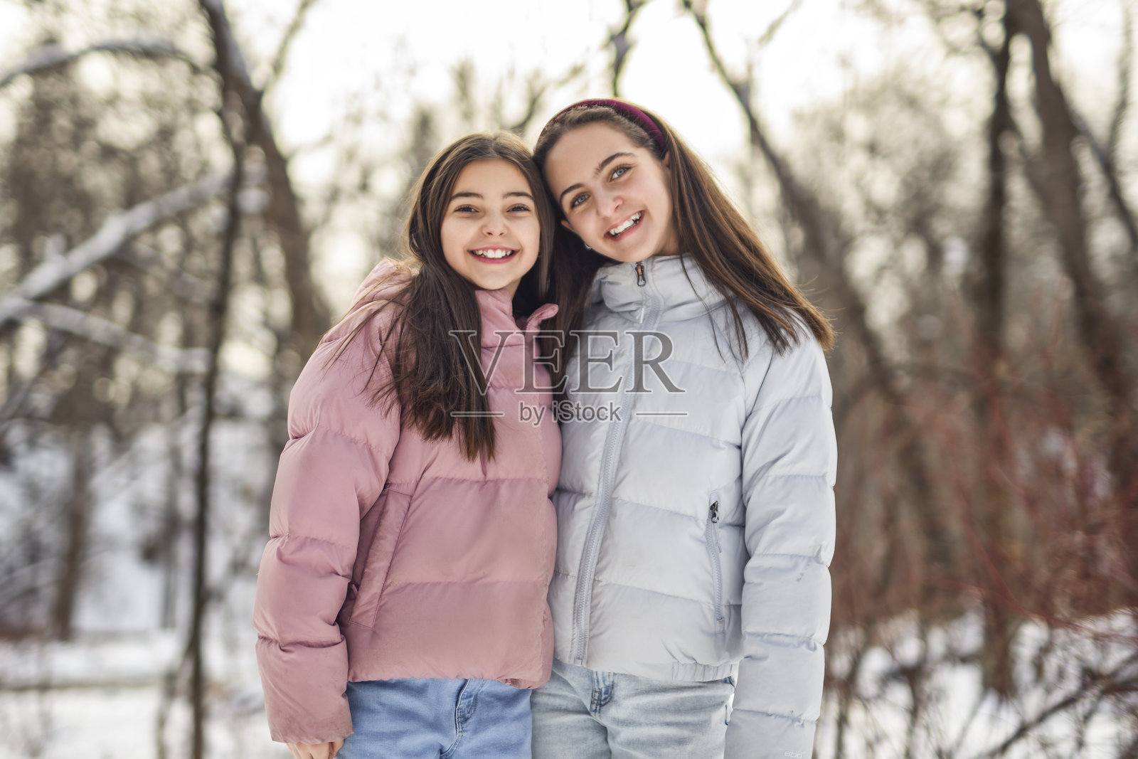 寒冷冬日,两位朋友在户外。照片摄影图片